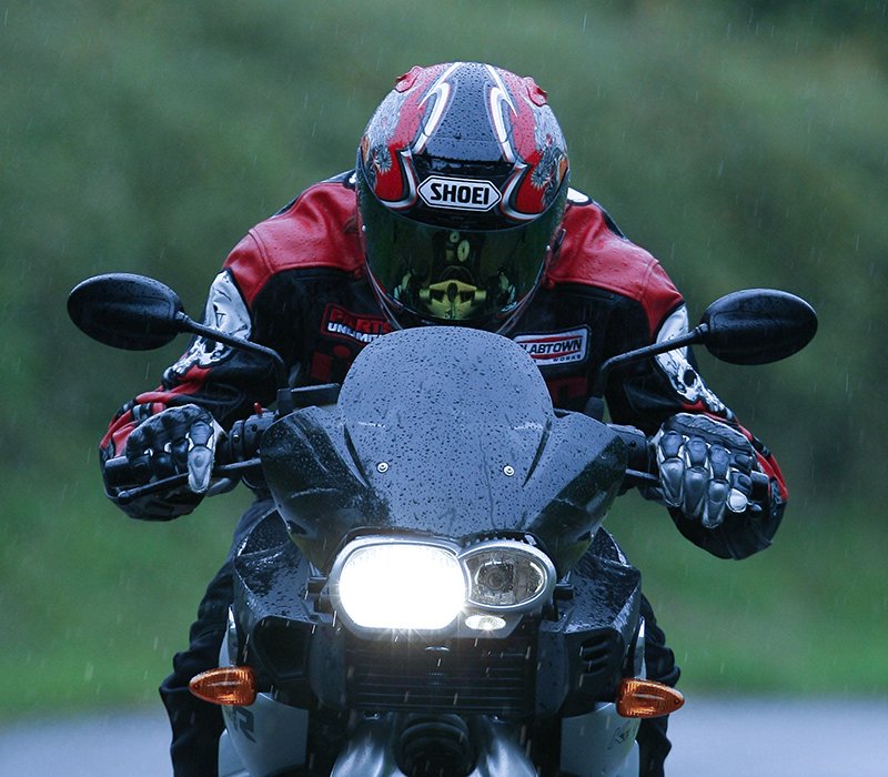 Guy riding motorcycle wearing leathers in rain